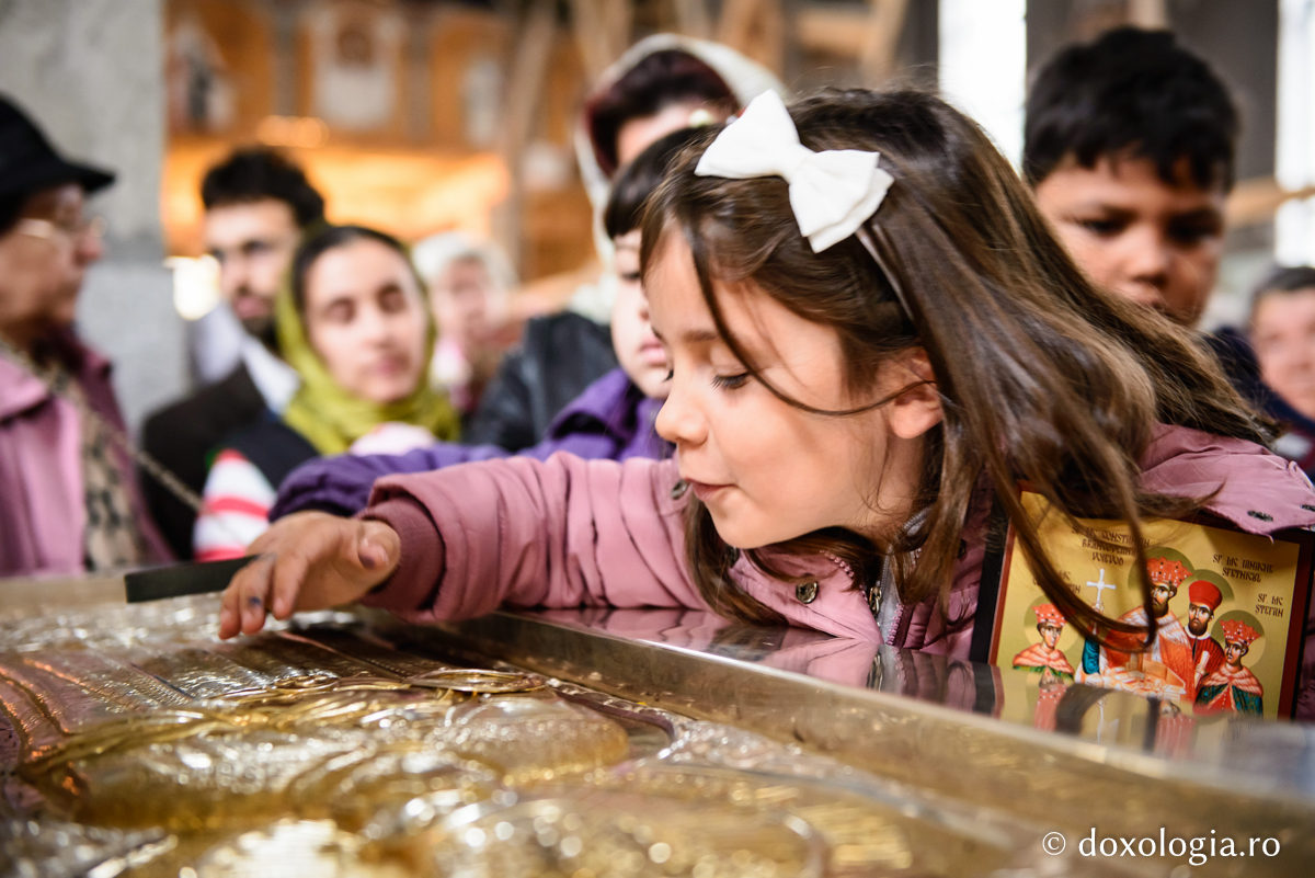 Să-i avem pe sfinți drept prieteni / Foto: Oana Nechifor copilă închinându-se la sfintele moaște