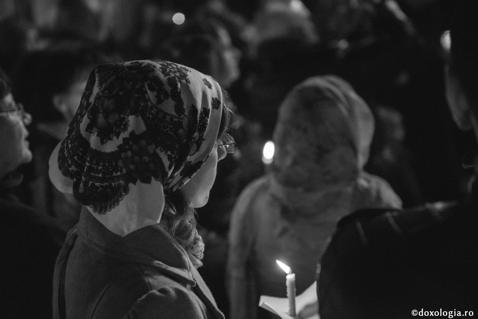 În genunchi la rugăciune, dar cu gândurile risipite, pierdem toată răsplata / Foto: Oana Nechifor femeie cu lumânare aprinsă în mână