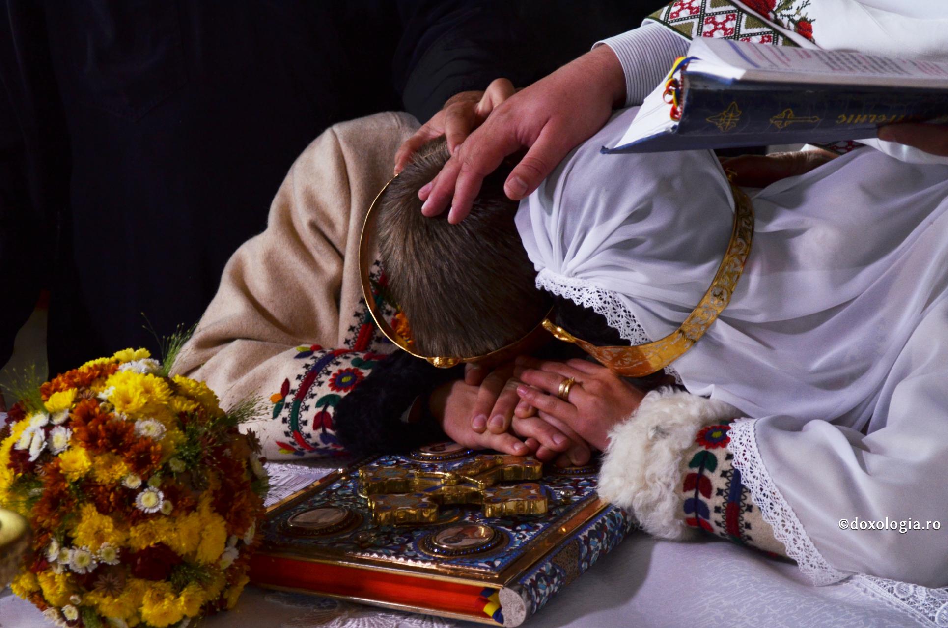 Explicația expresiei „cei doi soți devin una” / Foto: Valentina Bîrgăoanu miri cu fruntea pe Sfânta Evanghelie
