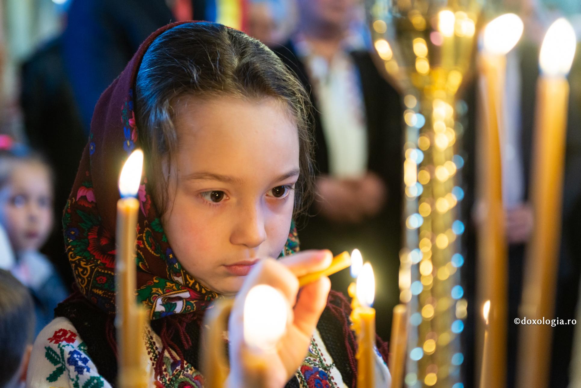 Un moment de fericire cu Dumnezeu / Foto: Bogdan Bulgariu fetiță aprinzând lumânarea