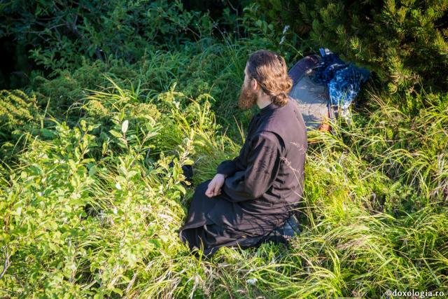 călugăr în genunchi pe iarbă