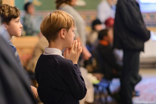 copil cu mâinile împreunate la rugăciune