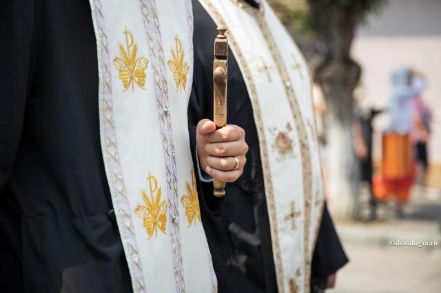 preot cu cruce de lemn în mână