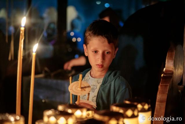 Copil cu lumânare aprinsă la slujba Prohodului Maicii Domnului la mănăstirea Văratec