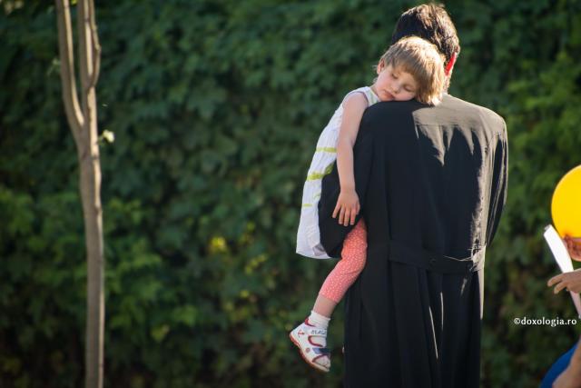 preot cu fiica în brațe