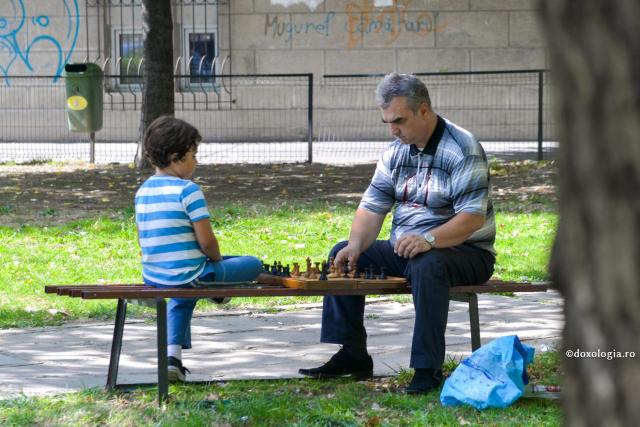 adult și copil jucând șah